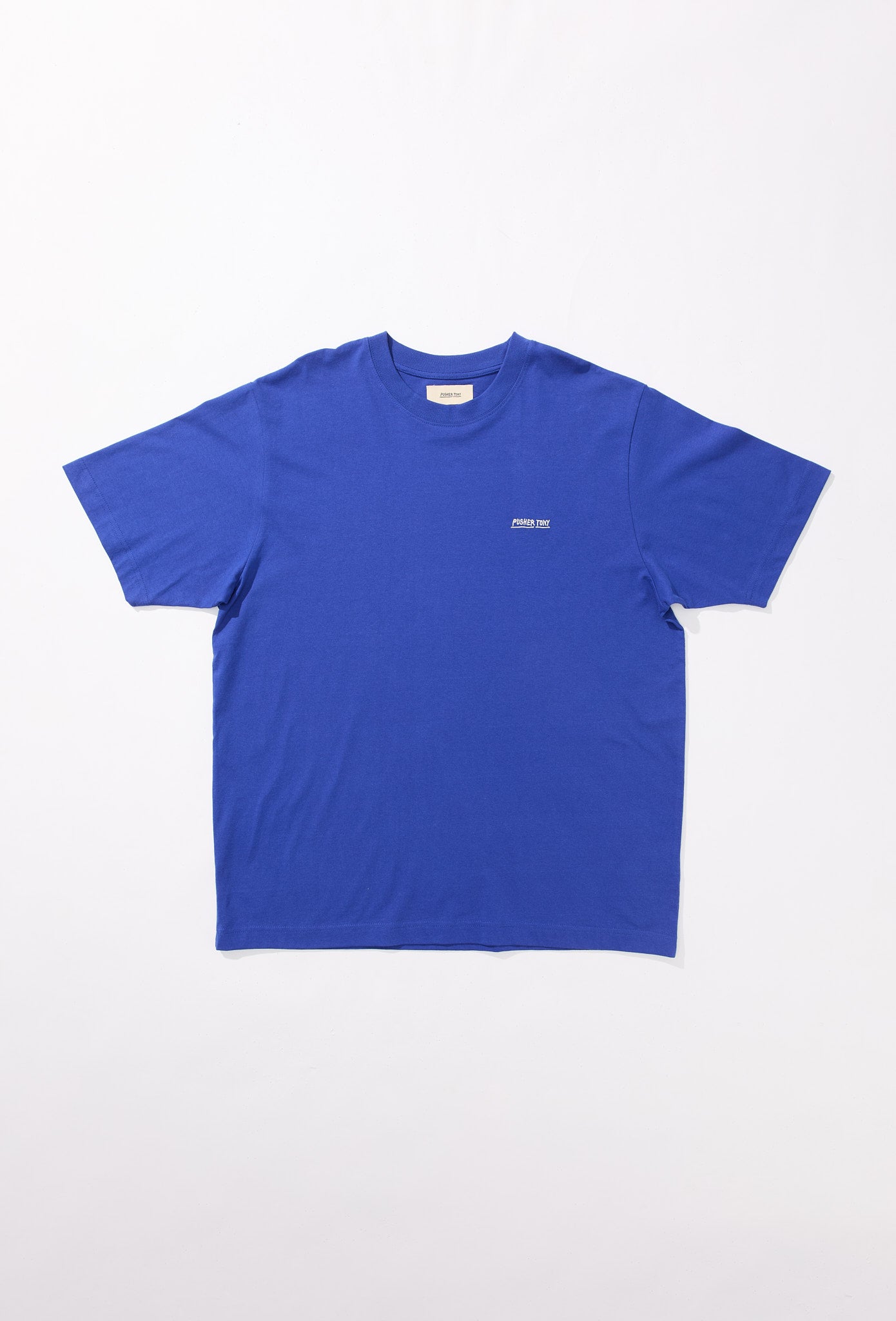 Kobaltblaues T-Shirt mit klassischem Rundhalsausschnitt und kurzen Ärmeln, flach auf weißem Hintergrund liegend. Auf der linken Brust befindet sich ein kleiner, weißer Schriftzug „PUSHER TONY“ im Blockstil. Das Design ist schlicht und modern mit einem dezenten Markenakzent auf der Vorderseite.